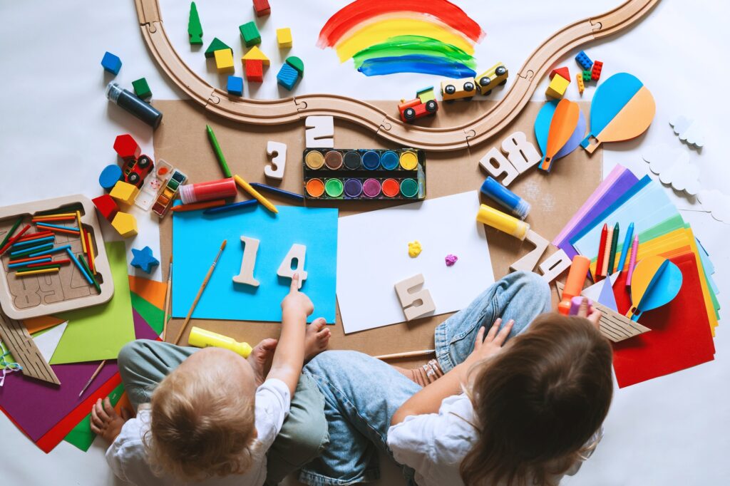 Children drawing and making crafts in kindergarten or daycare.