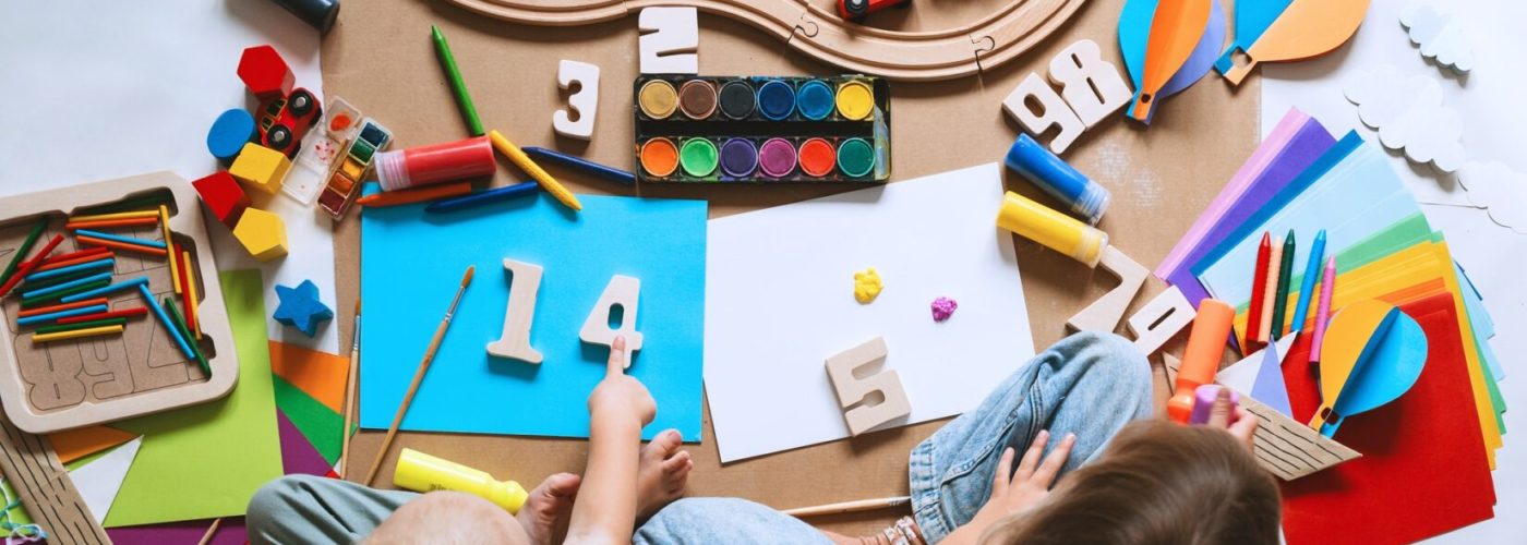 Children drawing and making crafts in kindergarten or daycare.